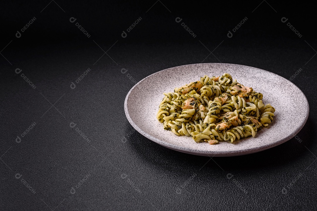 Deliciosa massa com espinafre, salmão, sal e especiarias sobre um fundo escuro de concreto