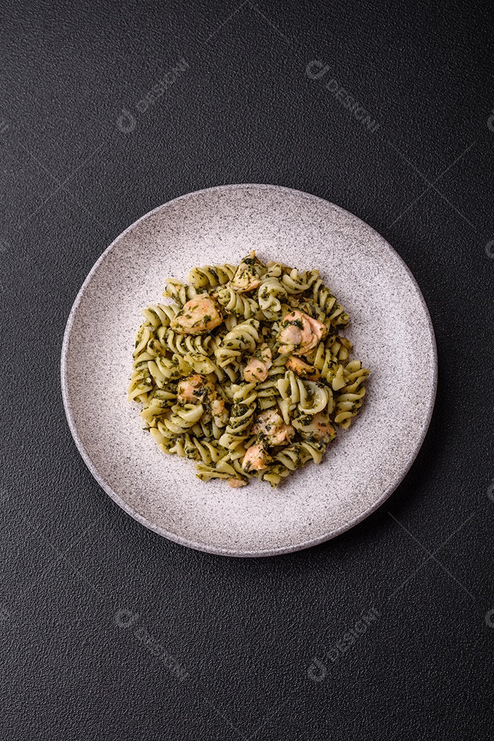 Deliciosa massa com espinafre, salmão, sal e especiarias sobre um fundo escuro de concreto