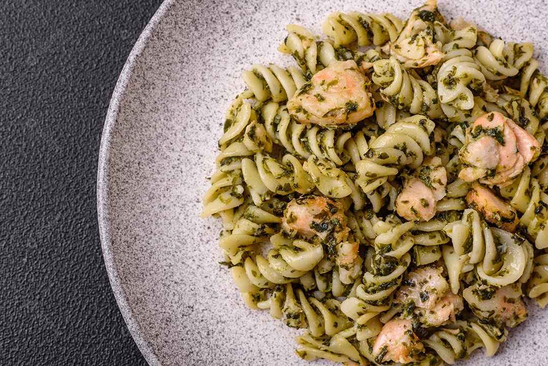 Deliciosa massa com espinafre, salmão, sal e especiarias sobre um fundo escuro de concreto