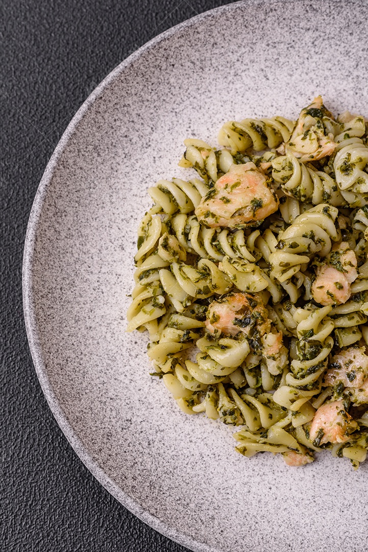Deliciosa massa com espinafre, salmão, sal e especiarias sobre um fundo escuro de concreto