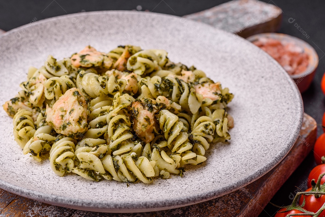 Deliciosa massa com espinafre, salmão, sal e especiarias sobre um fundo escuro de concreto