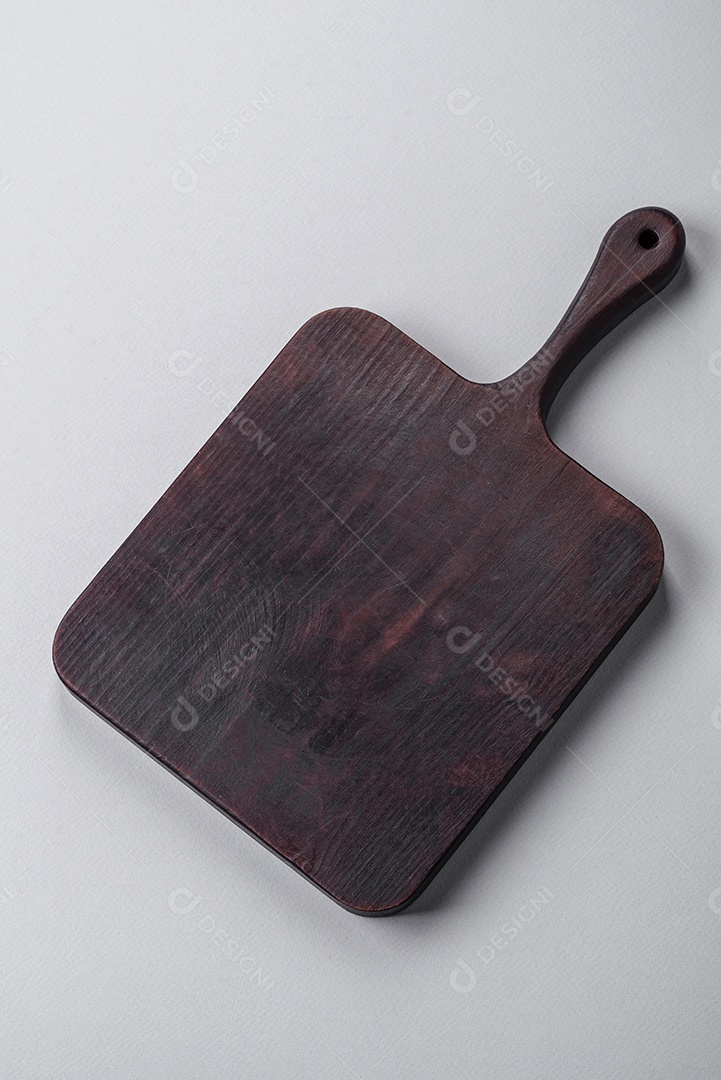 Tábua de corte de madeira vazia em fundo de concreto texturizado cinza. Talheres, preparação para o jantar