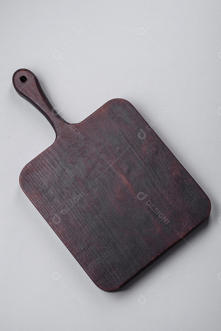 Tábua de corte de madeira vazia em fundo de concreto texturizado cinza. Talheres, preparação para o jantar