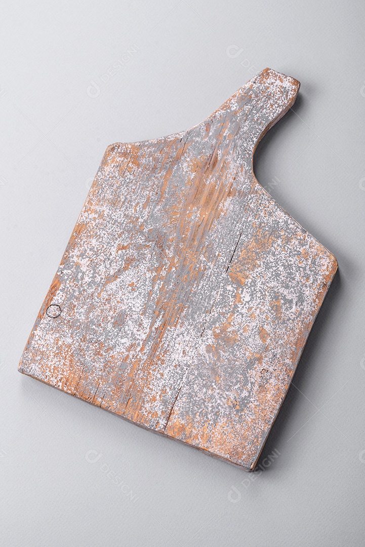 Tábua de corte de madeira vazia em fundo de concreto texturizado cinza. Talheres, preparação para o jantar