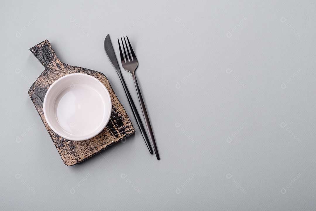 Um prato vazio sobre um fundo de concreto cinza. Cozinhar jantar em casa