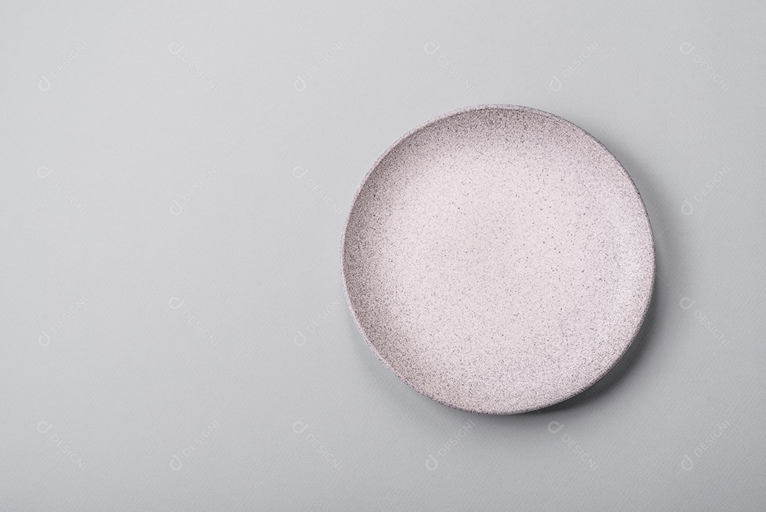 Um prato vazio sobre um fundo de concreto cinza. Cozinhar jantar em casa