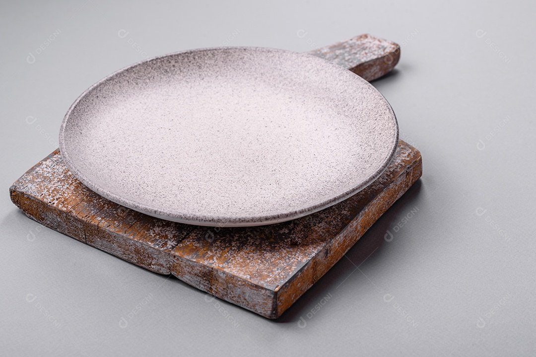 Um prato vazio sobre um fundo de concreto cinza. Cozinhar jantar em casa