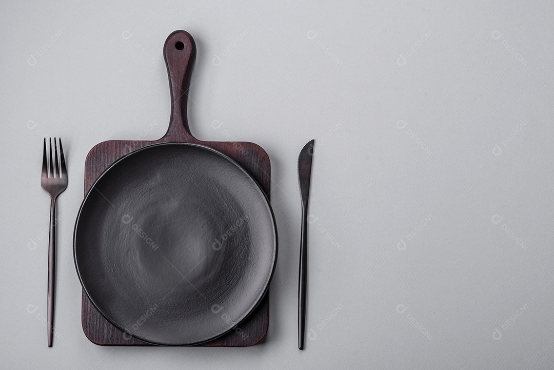 Um prato vazio sobre um fundo de concreto cinza. Cozinhar jantar em casa