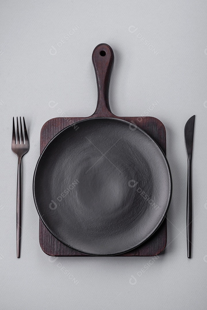 Um prato vazio sobre um fundo de concreto cinza. Cozinhar jantar em casa