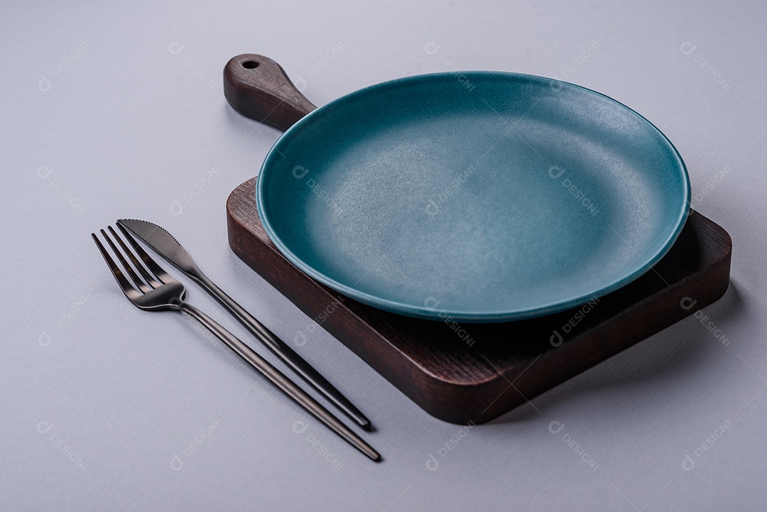 Um prato vazio sobre um fundo de concreto cinza. Cozinhar jantar em casa