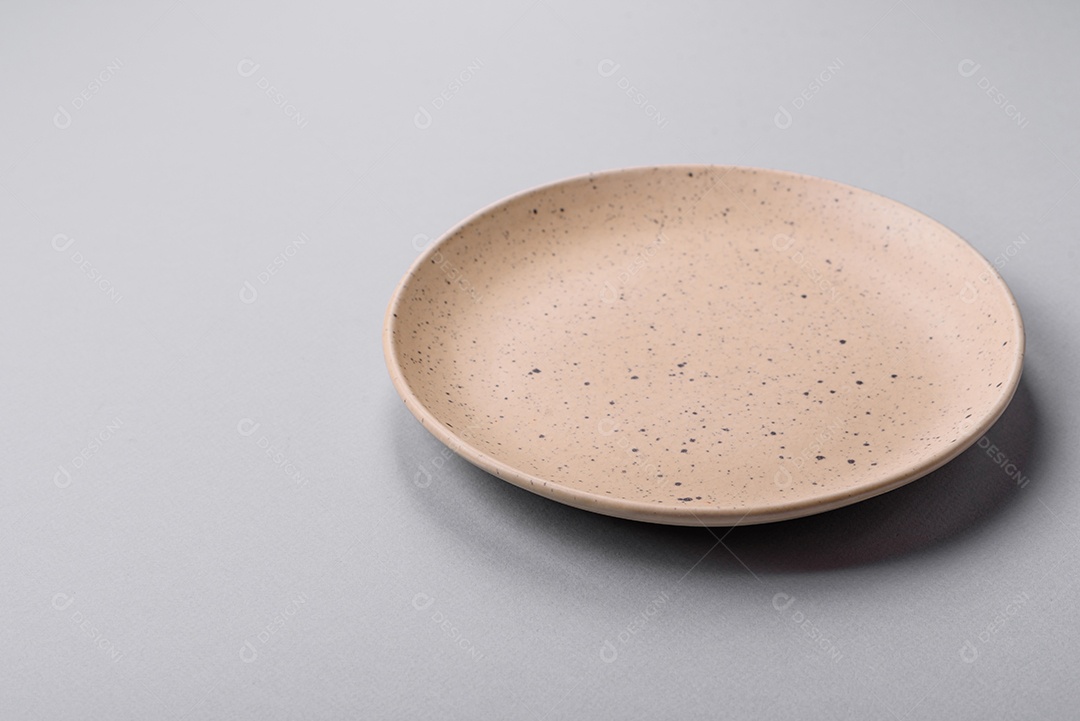 Um prato vazio sobre um fundo de concreto cinza. Cozinhar jantar em cas