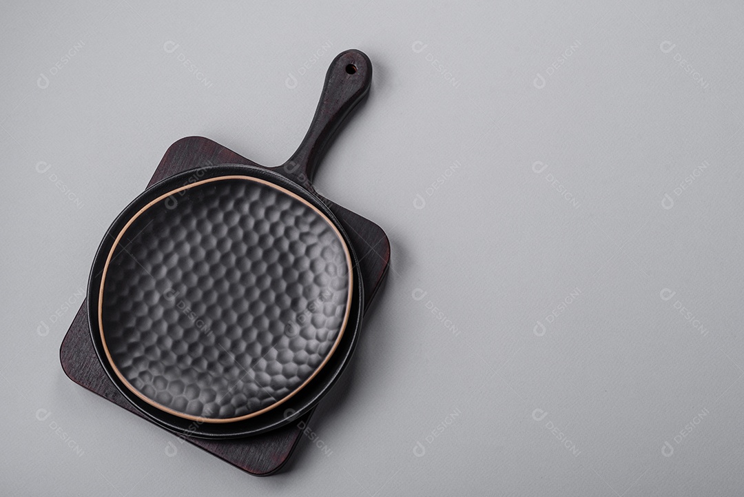 Um prato vazio sobre um fundo de concreto cinza. Cozinhar jantar em casa