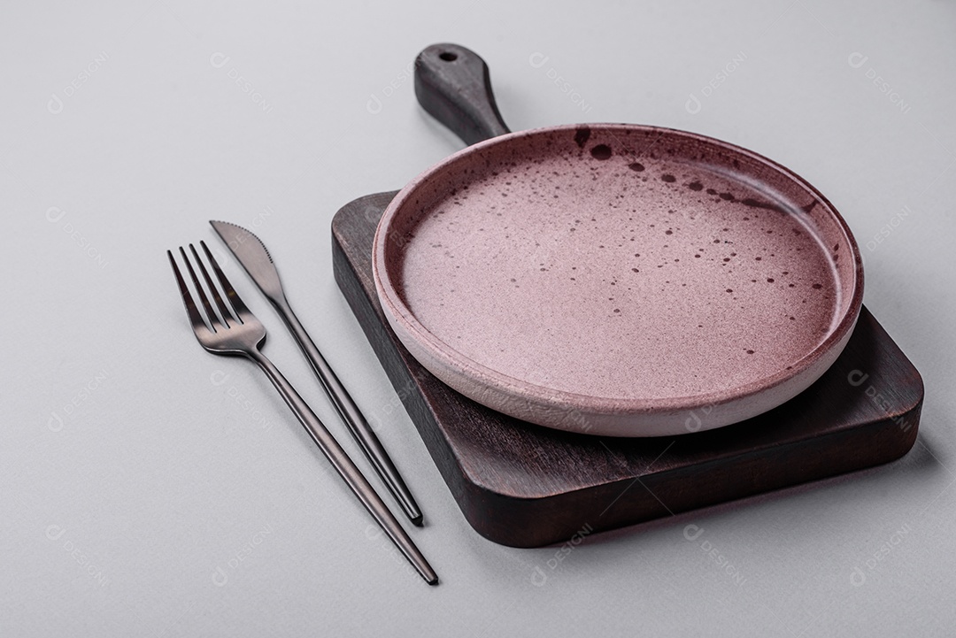 Um prato vazio sobre um fundo de concreto cinza. Cozinhar jantar em casa