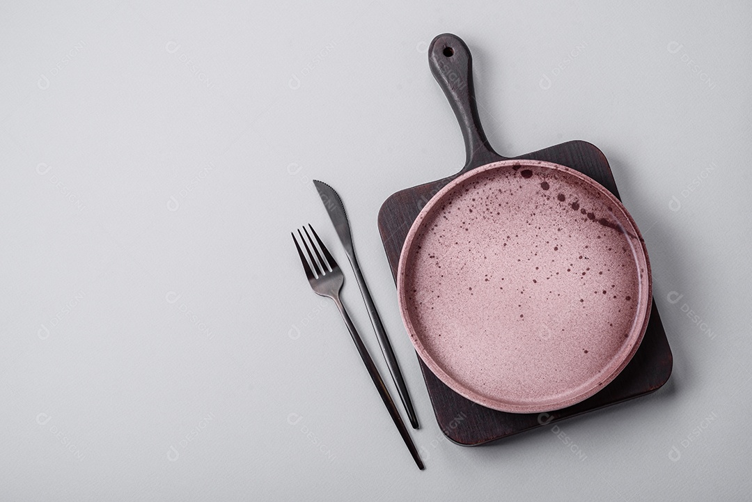 Um prato vazio sobre um fundo de concreto cinza. Cozinhar jantar em casa