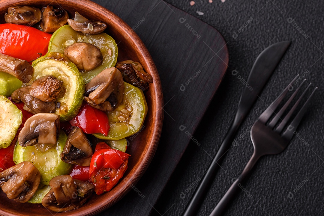 Deliciosos legumes grelhados, batatas, tomates, pimentões, berinjela com sal, especiarias e ervas em um fundo escuro de concreto