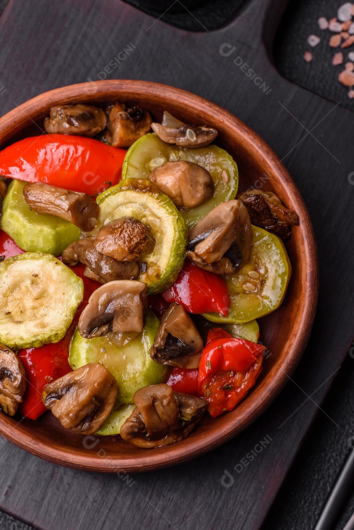 Deliciosos legumes grelhados, batatas, tomates, pimentões, berinjela com sal, especiarias e ervas em um fundo escuro de concreto