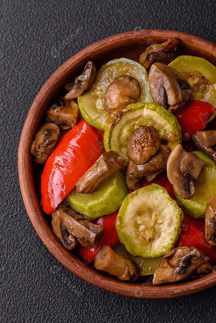 Deliciosos legumes grelhados, batatas, tomates, pimentões, berinjela com sal, especiarias e ervas em um fundo escuro de concreto