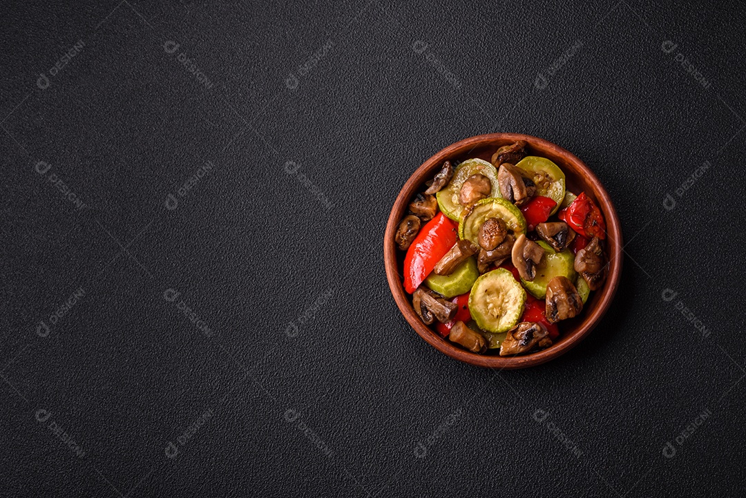 Deliciosos legumes grelhados, batatas, tomates, pimentões, berinjela com sal, especiarias e ervas em um fundo escuro de concreto