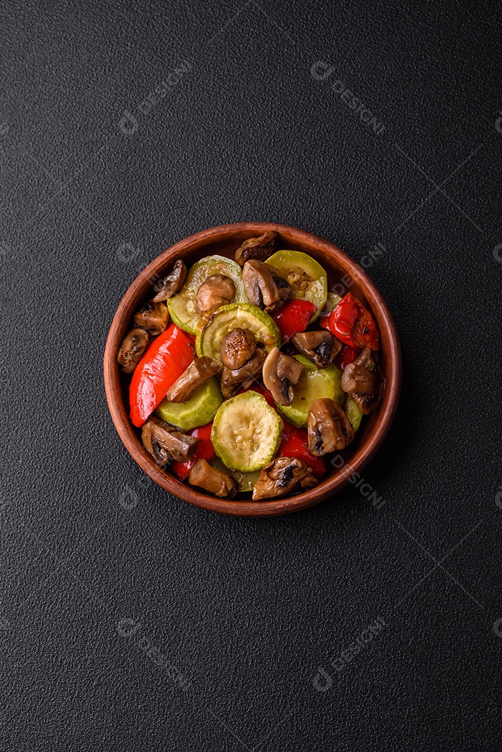 Deliciosos legumes grelhados, batatas, tomates, pimentões, berinjela com sal, especiarias e ervas em um fundo escuro de concreto