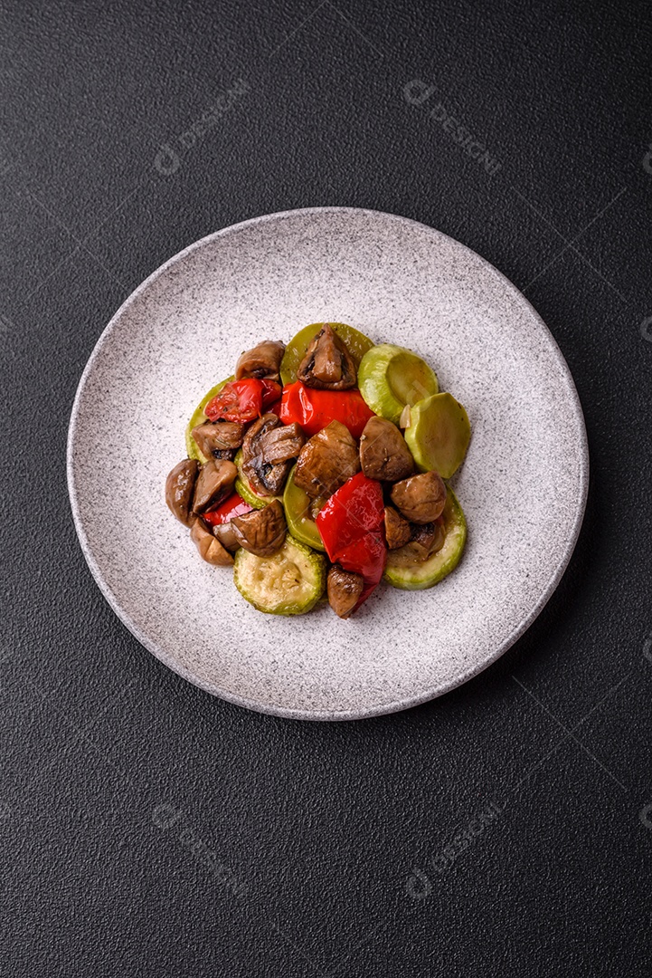 Deliciosos legumes grelhados, batatas, tomates, pimentões, berinjela com sal, especiarias e ervas em um fundo escuro de concreto