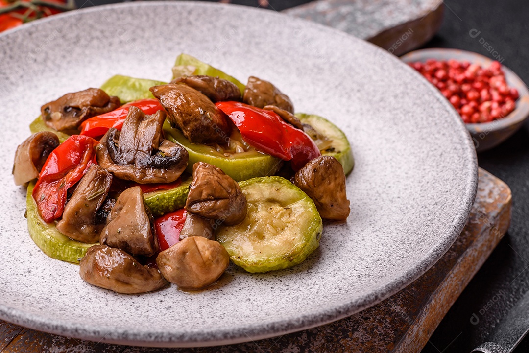 Deliciosos legumes grelhados, batatas, tomates, pimentões, berinjela com sal, especiarias e ervas em um fundo escuro de concreto