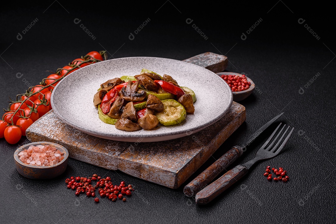 Deliciosos legumes grelhados, batatas, tomates, pimentões, berinjela com sal, especiarias e ervas em um fundo escuro de concreto