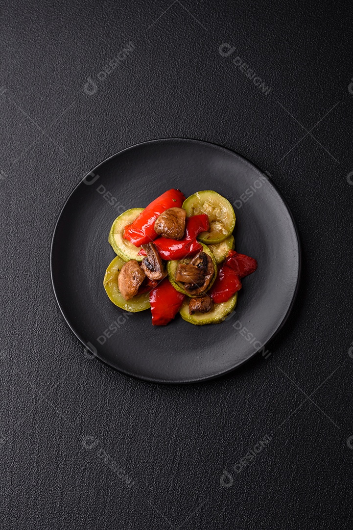 Deliciosas abobrinhas frescas grelhadas, pimentões, cogumelos e cebolas assadas na grelha com sal, especiarias e ervas