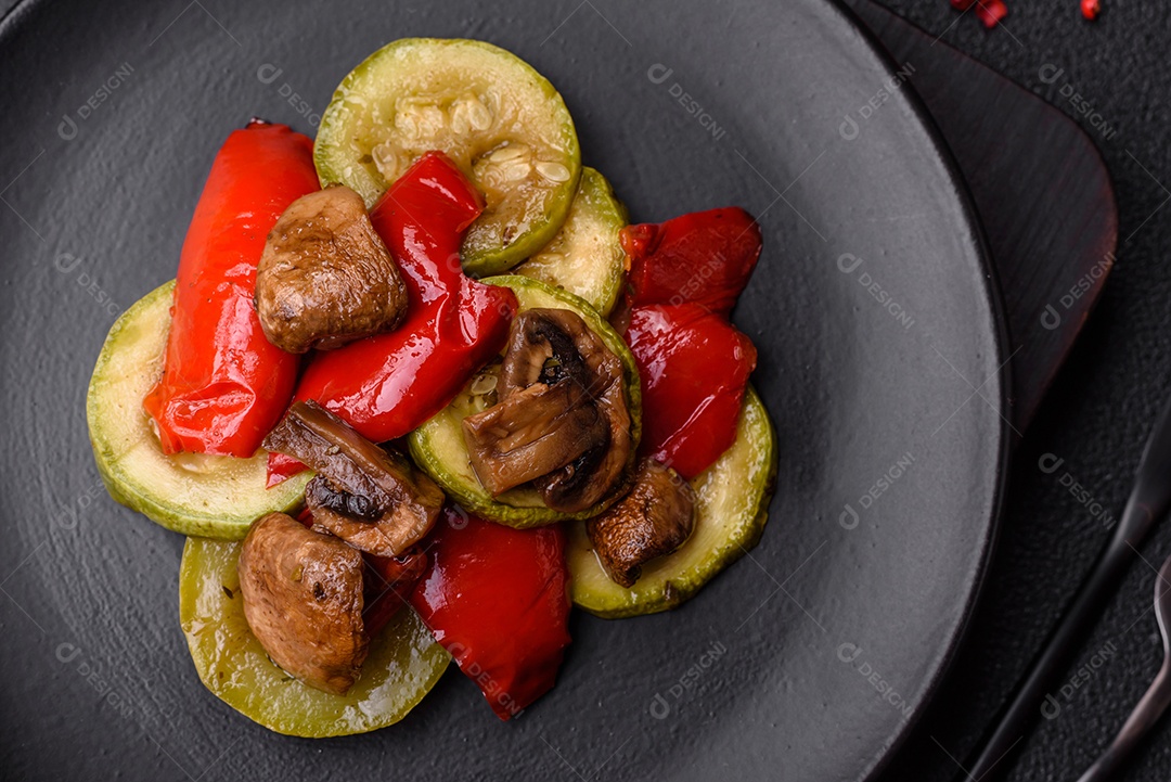 Deliciosas abobrinhas frescas grelhadas, pimentões, cogumelos e cebolas assadas na grelha com sal, especiarias e ervas