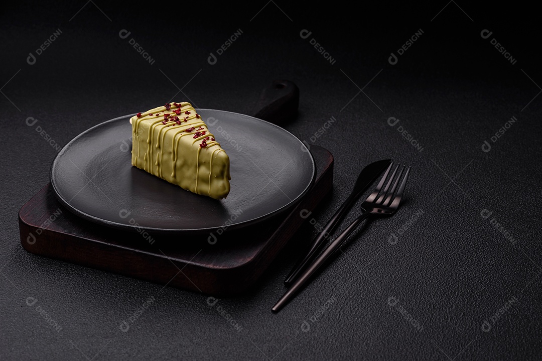 Delicioso cheesecake doce com frutas cobertas de glacê com uma vara de madeira sobre um fundo escuro de concreto