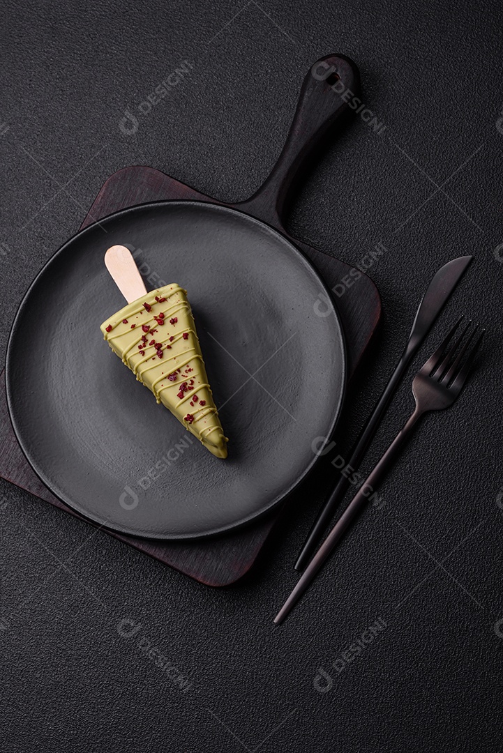 Delicioso cheesecake doce com frutas cobertas de glacê com uma vara de madeira sobre um fundo escuro de concreto