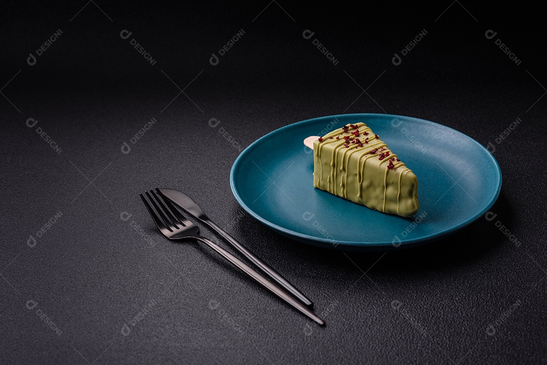 Delicioso cheesecake doce com frutas cobertas de glacê com uma vara de madeira sobre um fundo escuro de concreto