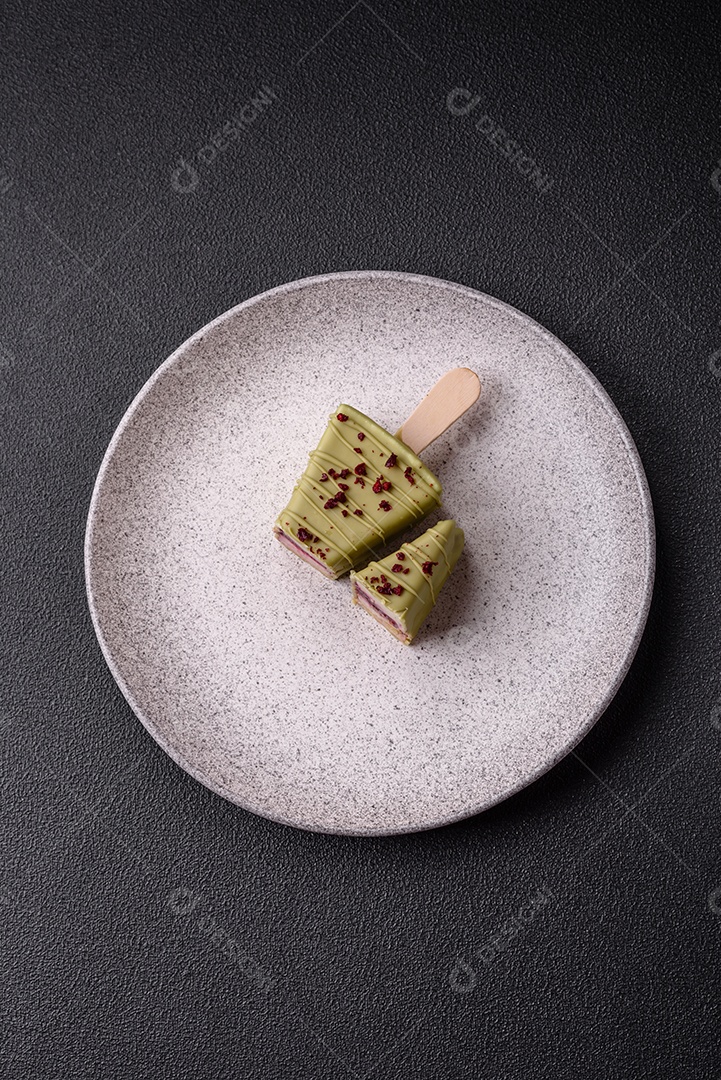 Delicioso cheesecake doce com frutas cobertas de glacê com uma vara de madeira sobre um fundo escuro de concreto