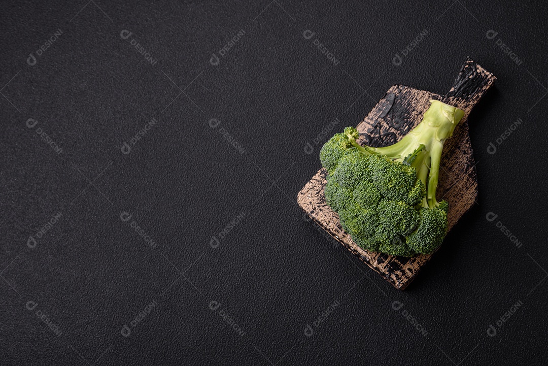 Manjericão de ervas frescas em forma de arbusto como ingrediente para cozinhar em casa sobre um fundo escuro de concreto