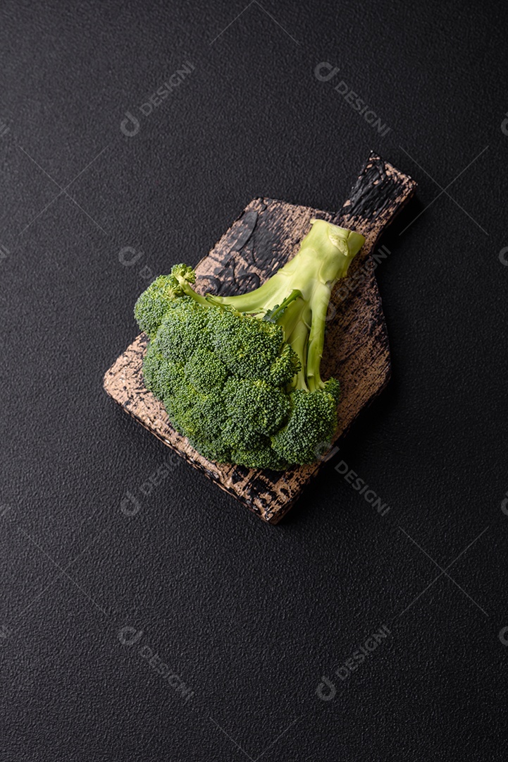 Manjericão de ervas frescas em forma de arbusto como ingrediente para cozinhar em casa sobre um fundo escuro de concreto