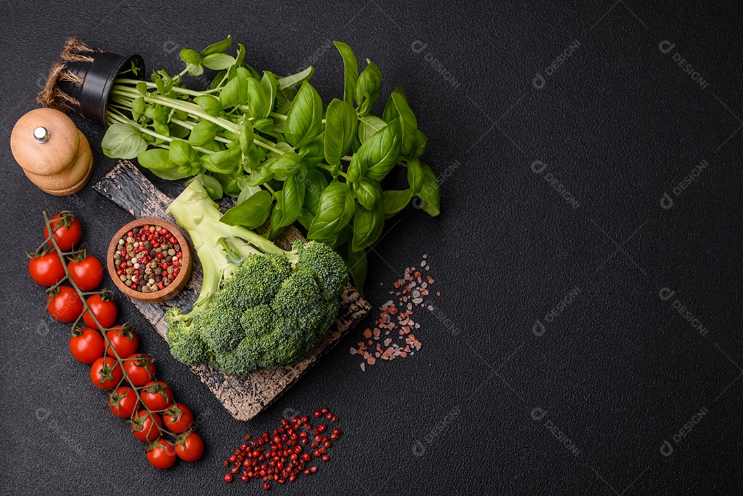 Manjericão de ervas frescas em forma de arbusto como ingrediente para cozinhar em casa sobre um fundo escuro de concreto