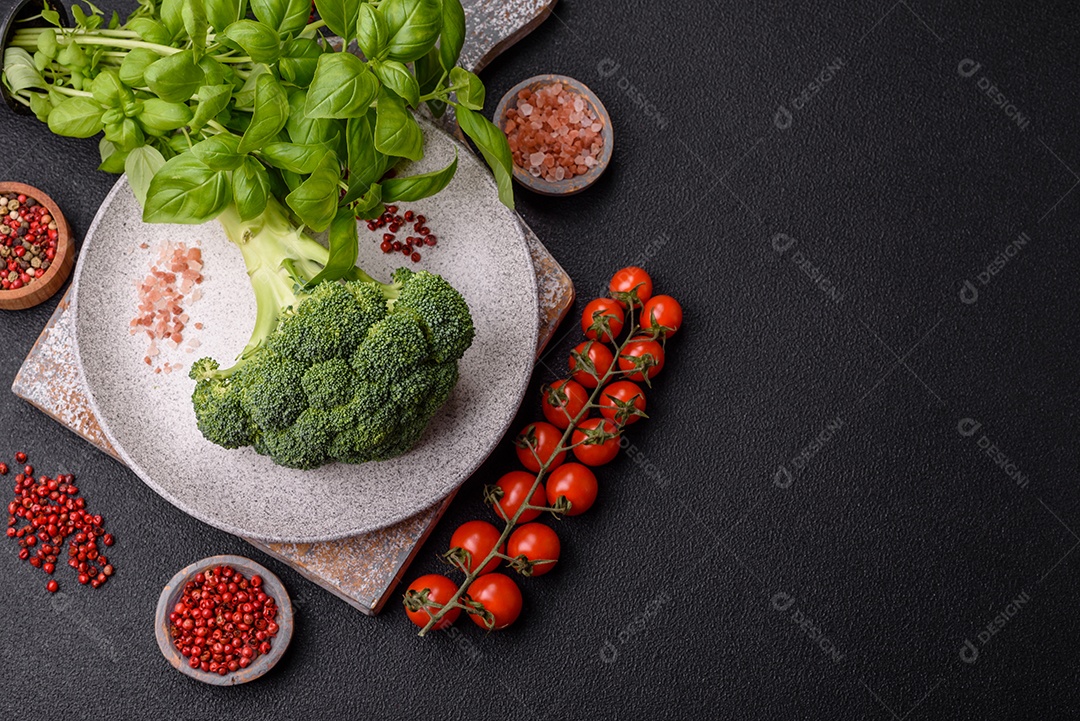 Manjericão de ervas frescas em forma de arbusto como ingrediente para cozinhar em casa sobre um fundo escuro de concreto