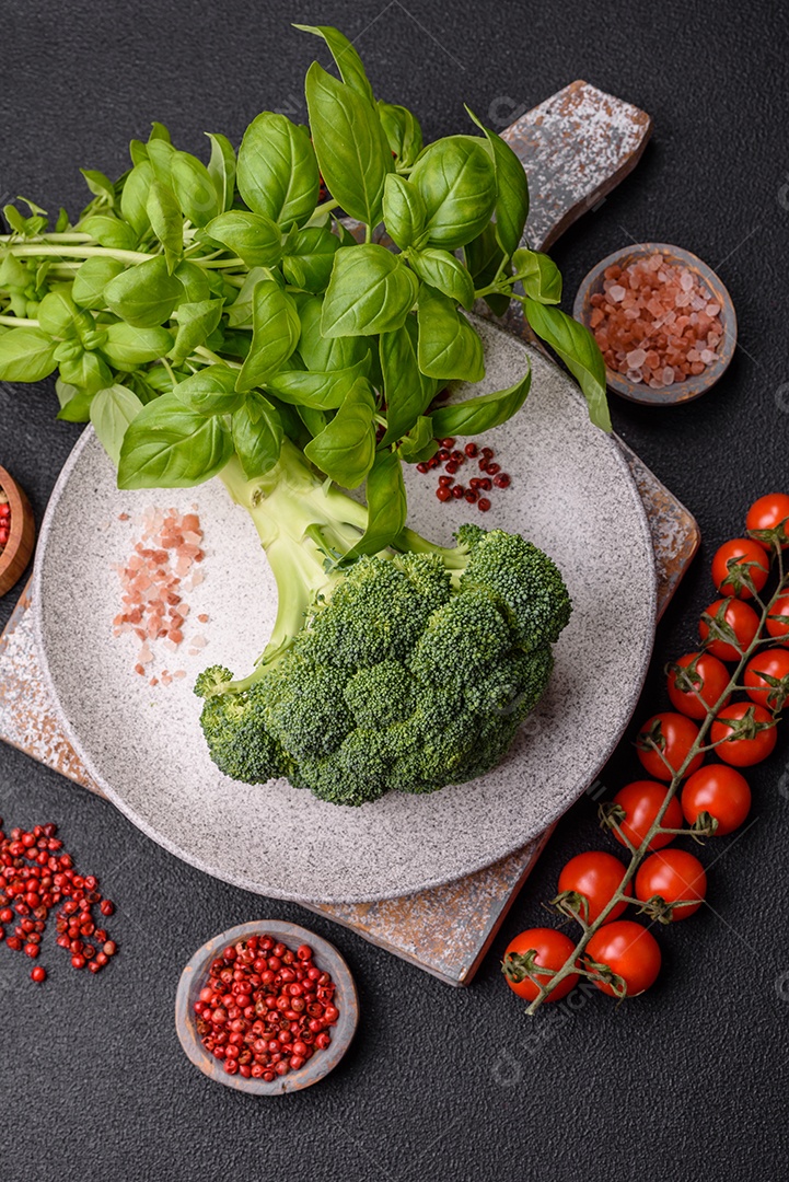 Manjericão de ervas frescas em forma de arbusto como ingrediente para cozinhar em casa sobre um fundo escuro de concreto