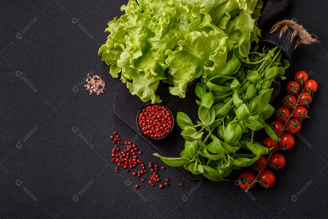 Manjericão de ervas frescas em forma de arbusto como ingrediente para cozinhar em casa sobre um fundo escuro de concreto
