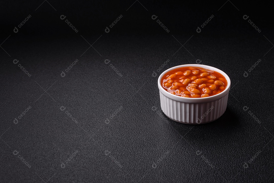 Delicioso feijão enlatado nutritivo com tomate, com sal e temperos como complemento de alto teor calórico para o café da manhã