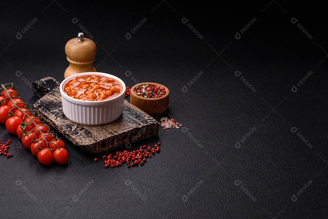 Delicioso feijão enlatado nutritivo com tomate, com sal e temperos como complemento de alto teor calórico para o café da manhã