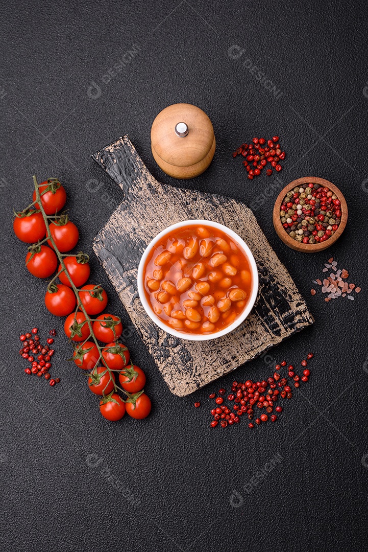 Delicioso feijão enlatado nutritivo com tomate, com sal e temperos como complemento de alto teor calórico para o café da manhã