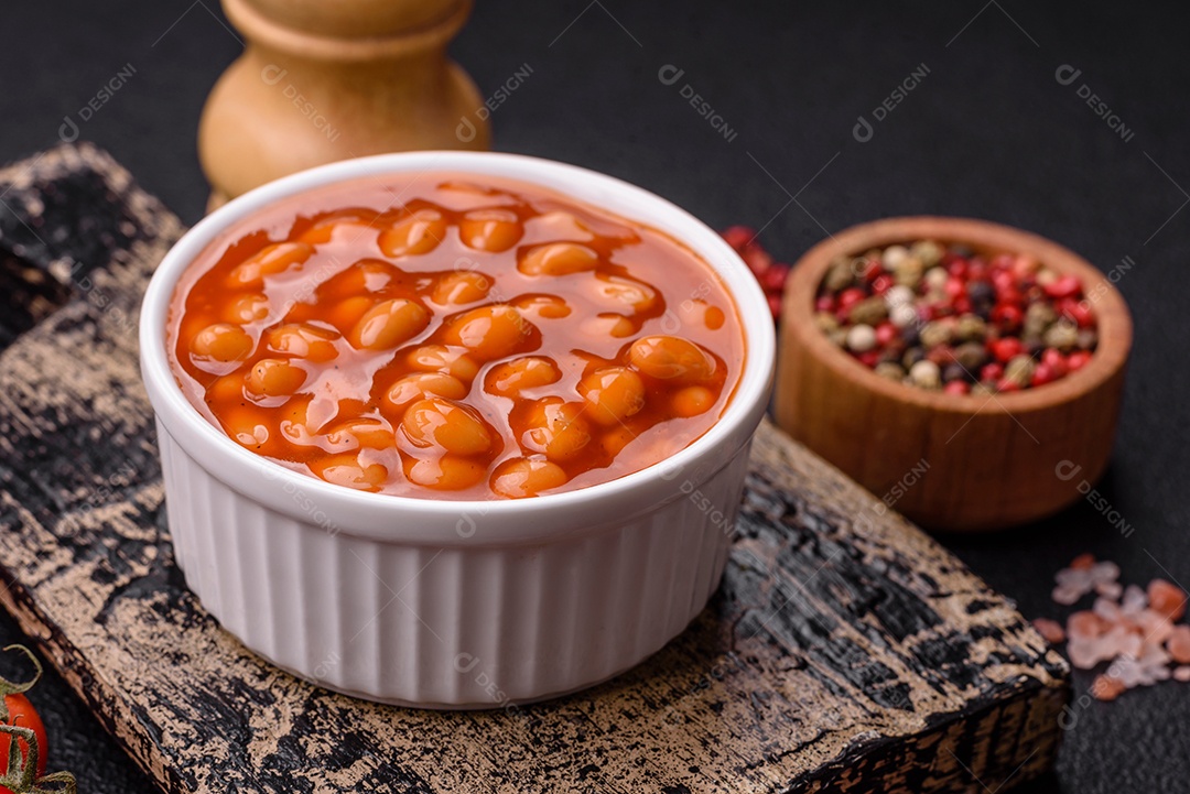 Delicioso feijão enlatado nutritivo com tomate, com sal e temperos como complemento de alto teor calórico para o café da manhã