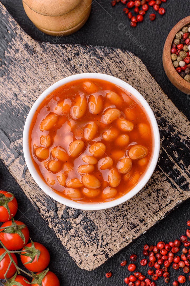 Delicioso feijão enlatado nutritivo com tomate, com sal e temperos como complemento de alto teor calórico para o café da manhã