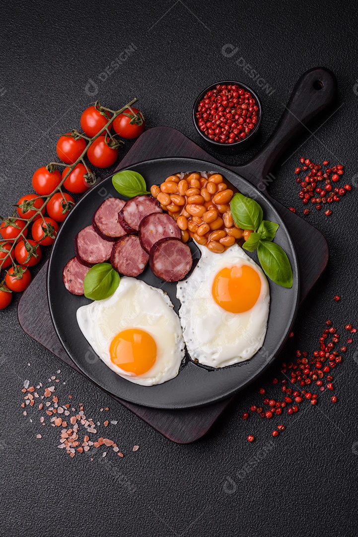 Café da manhã inglês com ovos fritos, bacon, feijão, tomate, especiarias e ervas. Um início de dia saudável e nutritivo