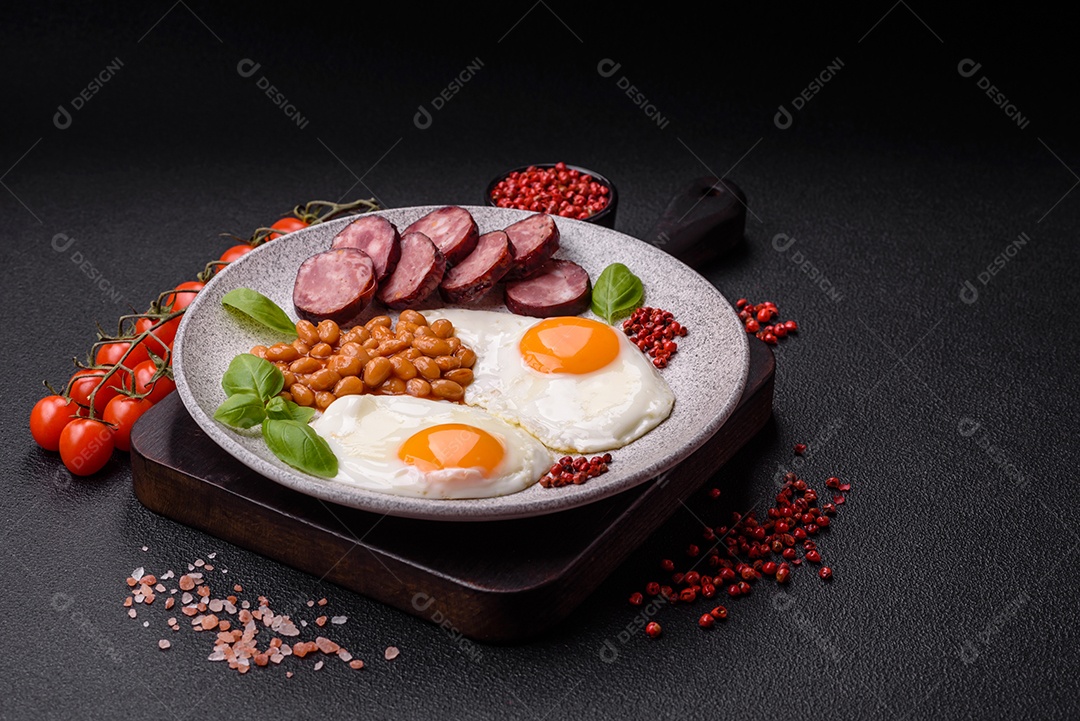 Café da manhã inglês com ovos fritos, bacon, feijão, tomate, especiarias e ervas. Um início de dia saudável e nutritivo
