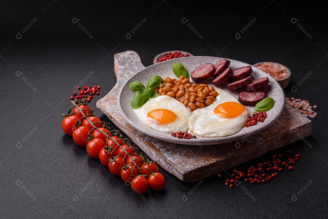 Café da manhã inglês com ovos fritos, bacon, feijão, tomate, especiarias e ervas. Um início de dia saudável e nutritivo