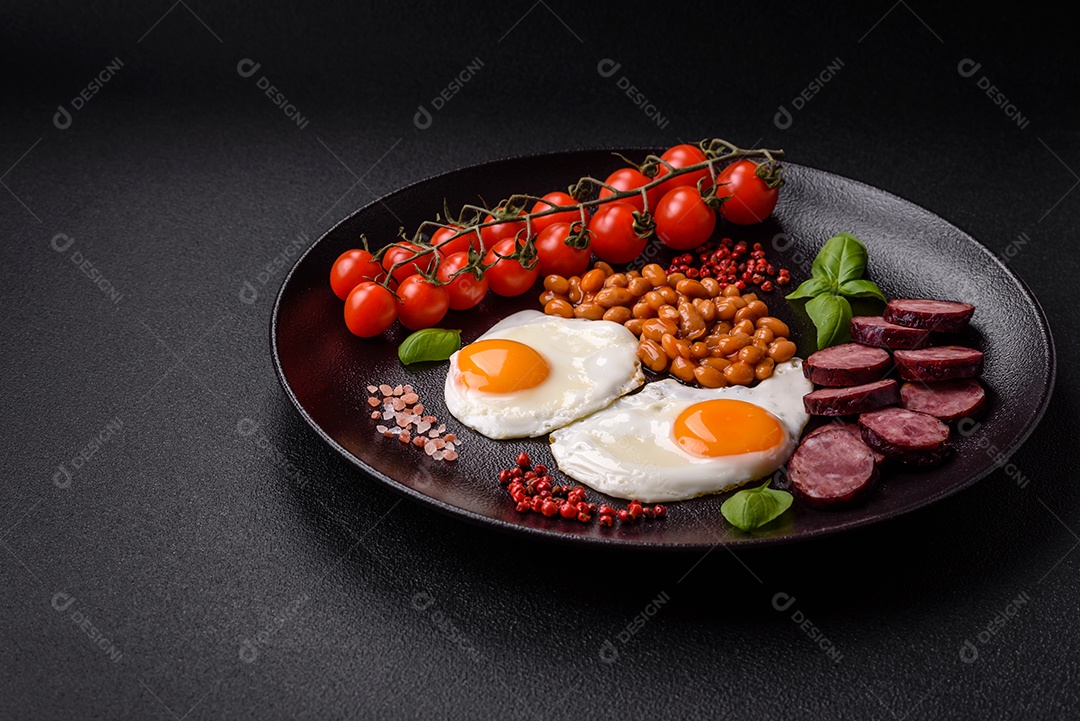 Café da manhã inglês com ovos fritos, bacon, feijão, tomate, especiarias e ervas. Um início de dia saudável e nutritivo