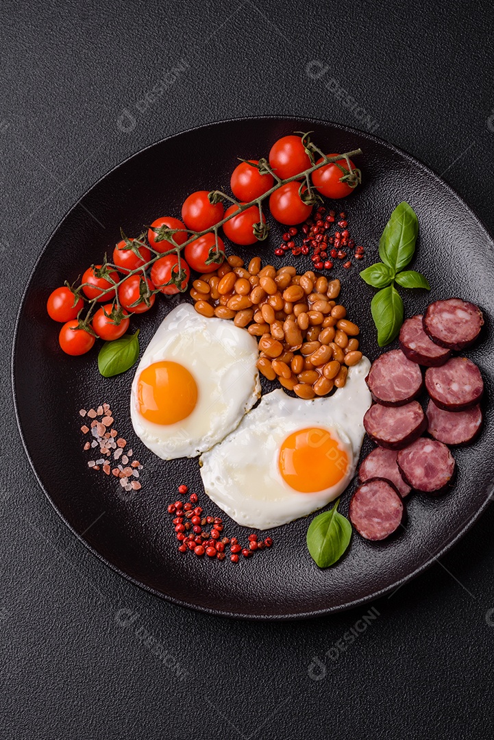 Café da manhã inglês com ovos fritos, bacon, feijão, tomate, especiarias e ervas. Um início de dia saudável e nutritivo
