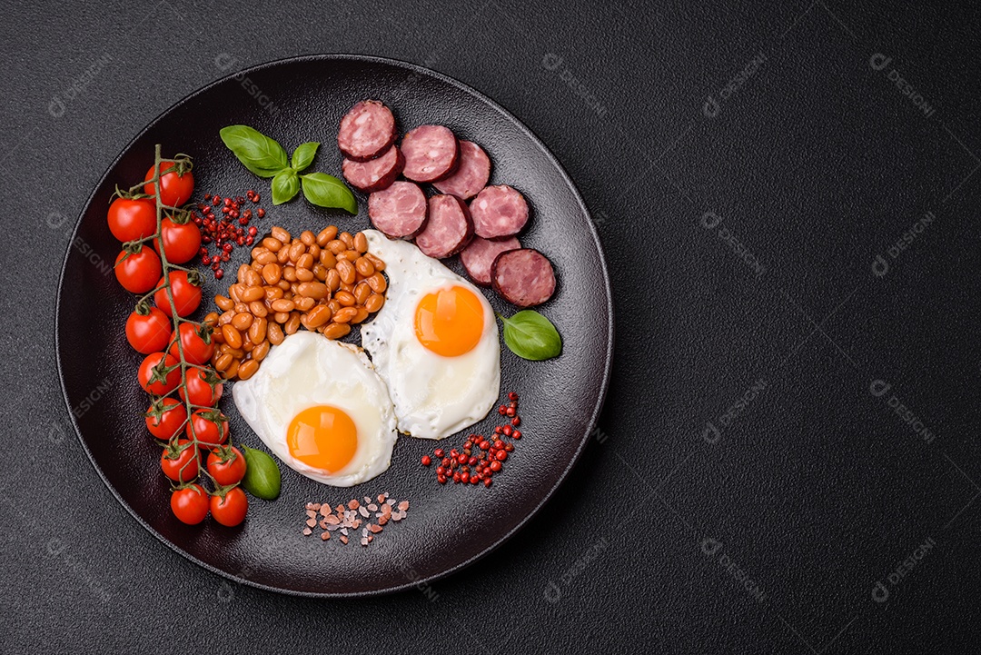 Café da manhã inglês com ovos fritos, bacon, feijão, tomate, especiarias e ervas. Um início de dia saudável e nutritivo