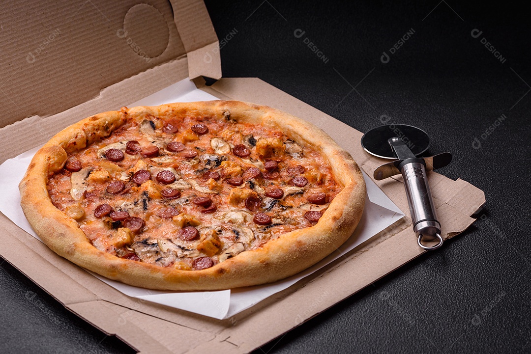 Deliciosa pizza com salsicha, queijo, tomate, sal, especiarias e ervas sobre um fundo escuro de concreto